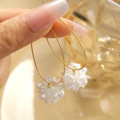 Aretes de camelia blanca con diseño delicado y elegante en metal dorado