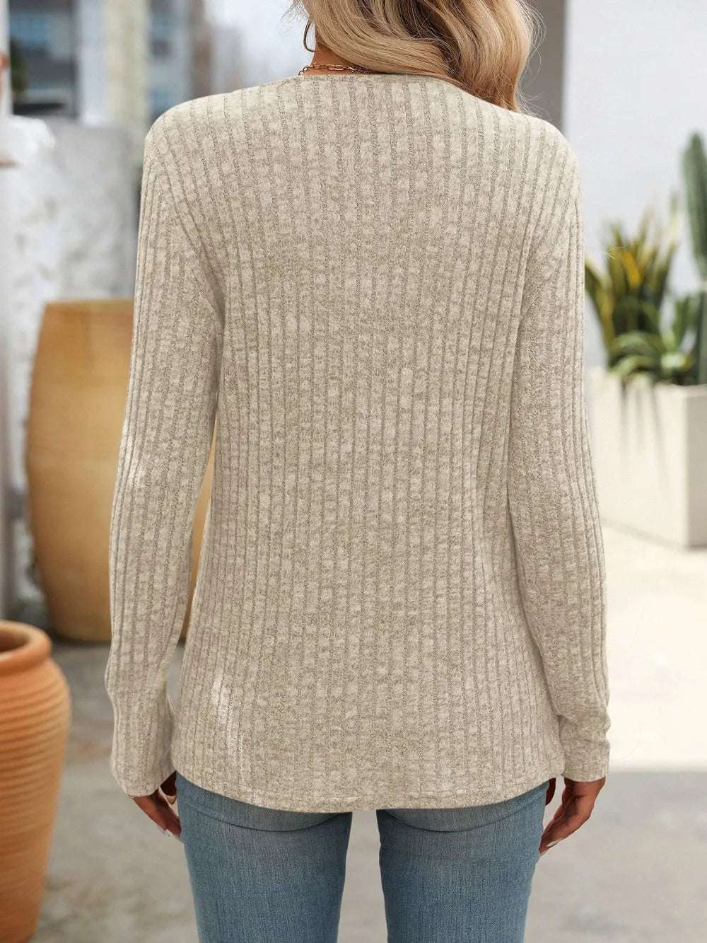 Blusa con botones moderna de punto acanalado en color beige, vista trasera con diseño elegante
