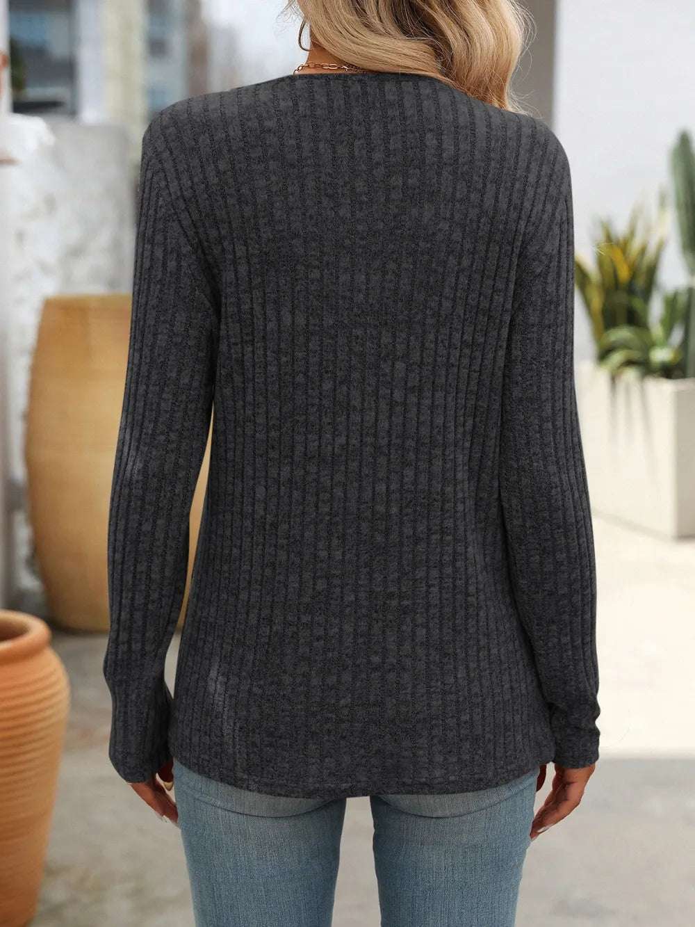 Vista trasera de una blusa con botones moderna en color gris con diseño de canalé para un look elegante