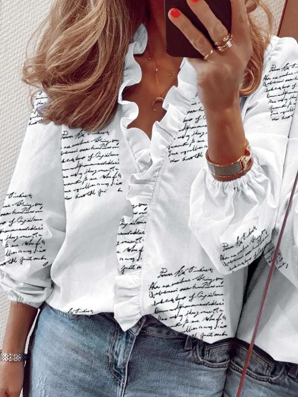 Mujer usando una blusa estampada con volantes blanca con detalles de escritura en negro