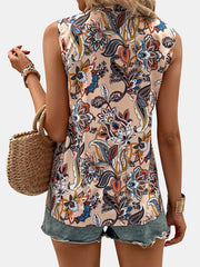 Mujer con blusa sin mangas estampada en tonos claros y flores vibrantes, combinada con shorts de mezclilla.